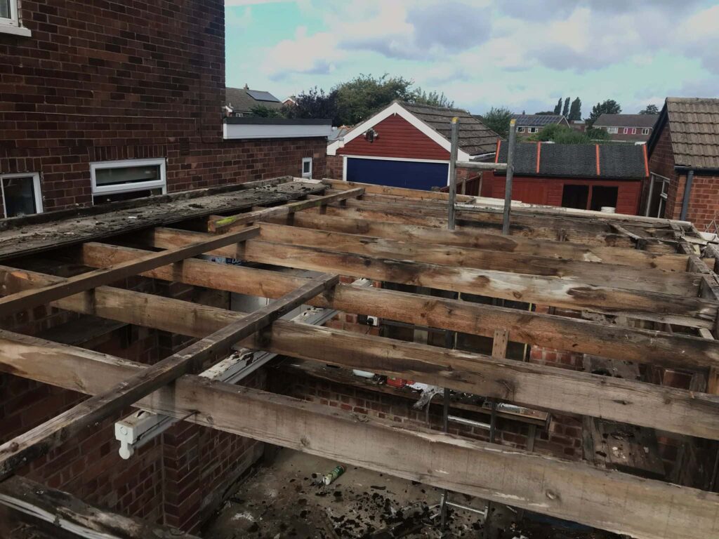 This is a photo of an old flat roof structure that has been stripped back to the timbers, and ready for replacement by Northampton Roofing Services