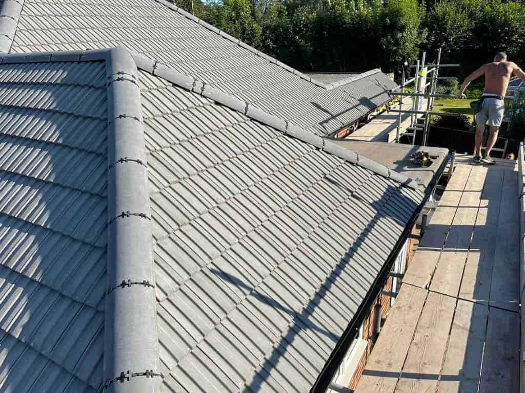 This is a photo of a re-roof that has just been completed with grey roof tiles, and a dry ridge and dry verge by Northampton Roofing Services